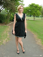 Hot Milf Monica posing in a gorgeous short black dress with matching shiny bumptious heels